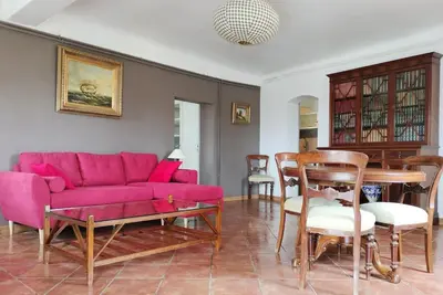 a living room with a pink couch and a table at Superbe T3 avec terrasse en plein cœur du centre historique in Aix-en-Provence