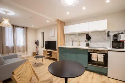 a kitchen and living room with a couch and a table at La Venise Provençale - Hypercentre - Wifi in LʼIsle-sur-la-Sorgue
