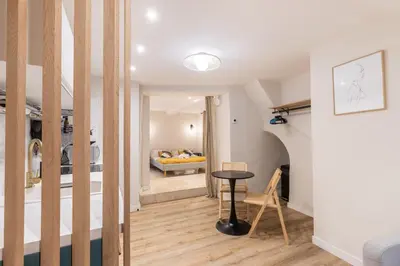 a living room with a bed and a table at La Venise Provençale - Hypercentre - Wifi in LʼIsle-sur-la-Sorgue