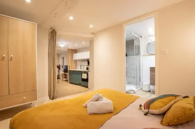 a bedroom with a large bed and a kitchen at La Venise Provençale - Hypercentre - Wifi in LʼIsle-sur-la-Sorgue