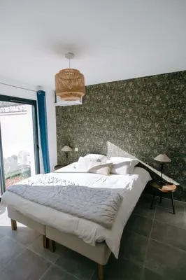 a bedroom with a large bed with a green wall at La Dolce Vita Provençale Charming House with its Private Swimming Pool in LʼIsle-sur-la-Sorgue