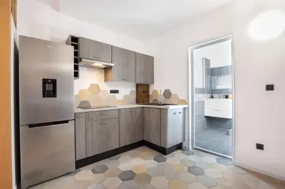 a kitchen with a stainless steel refrigerator and a shower at Le Duplex - Hypercentre - Wifi in Carpentras
