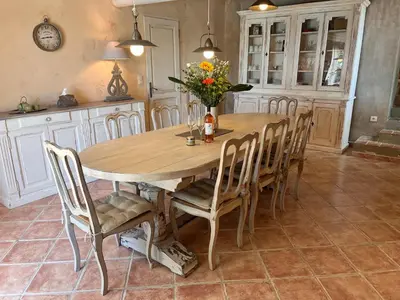 a dining room table with chairs and a vase of flowers at La Petite Paradisse – mas provençal exceptionnel in Blauvac