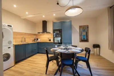 a kitchen with blue cabinets and a table and chairs at L'antiquaire - 3 chambres - Hypercentre - Wifi in LʼIsle-sur-la-Sorgue