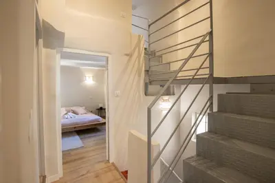 a staircase leading to a bedroom with a bed at L'antiquaire - 3 chambres - Hypercentre - Wifi in LʼIsle-sur-la-Sorgue