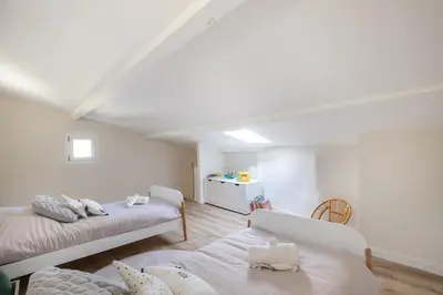 a white room with two beds and a table at L'antiquaire - 3 chambres - Hypercentre - Wifi in LʼIsle-sur-la-Sorgue