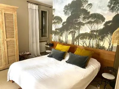 a bedroom with a white bed with yellow pillows at Villa des Alpilles in Eygalières
