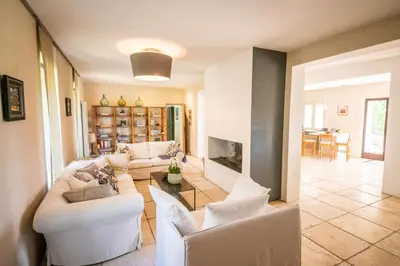 a living room with white couches and a fireplace at Villa des Alpilles in Eygalières