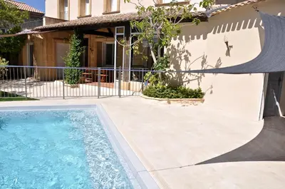 a swimming pool in front of a house at Maison de caractère au coeur de la Provence in Mallemort