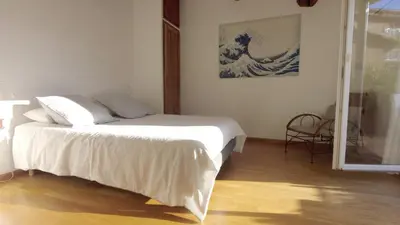 a bedroom with a bed and a painting of a wave at Lovely house teracce and parking in historic center in Aix-en-Provence
