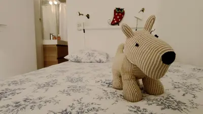 a stuffed teddy bear sitting on top of a bed at Lovely house teracce and parking in historic center in Aix-en-Provence