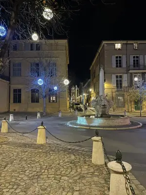 a fountain in the middle of a street at night at Lovely house teracce and parking in historic center in Aix-en-Provence