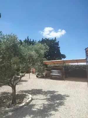 a car parked in a driveway with a tree at Chambre d hôte gite Au fond du jardin in Saint-Saturnin-lès-Avignon
