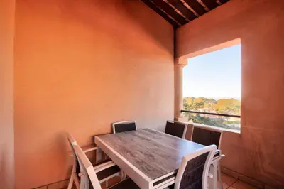 a table and chairs in a room with a window at Village Pont Royal en Provence - maeva Home - Appartement climatisé avec terrasse 4 pièces 7 personnes - Prestige - super Home MAE-3801 in Mallemort