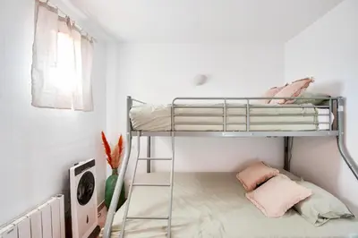 a bunk bed in a white room with pink pillows at Village Pont Royal en Provence - maeva Home - Appartement climatisé avec terrasse 4 pièces 7 personnes - Prestige - super Home MAE-3801 in Mallemort