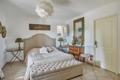 a bedroom with a bed and a table and a mirror at Maison de Golfeur in Mallemort