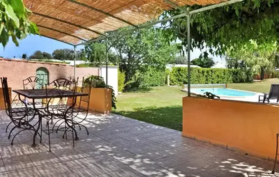 a patio with a table and chairs and a pool at La Villa Des Songes in Pernes-les-Fontaines