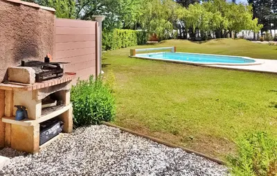 a backyard with a barbecue next to a swimming pool at La Villa Des Songes in Pernes-les-Fontaines
