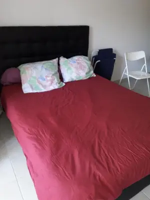 a bed with a red blanket and two pillows on it at Studio 007 à Aix in Aix-en-Provence