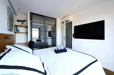 a bedroom with two beds and a flat screen tv at Aix Rooftop Appartement T2 Luxe 5 étoiles - hypercentre Rotonde - Terrasse - Vue - Parking in Aix-en-Provence