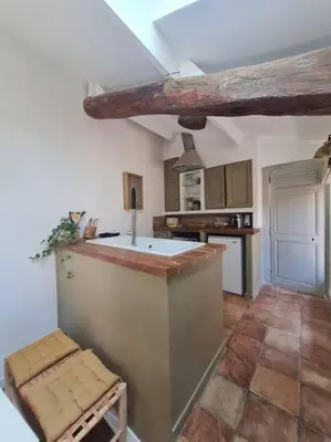 a kitchen with a counter and a island in a room at Appartement avec terrasse sur les toits classé 5* in LʼIsle-sur-la-Sorgue