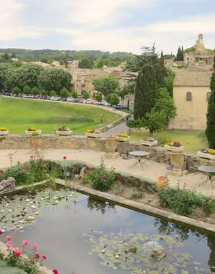 a view of a garden with a pond with flowers at Les Tarraïettes au pied du Luberon in Lourmarin