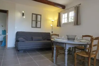 a living room with a table and a couch at Les Tarraïettes au pied du Luberon in Lourmarin