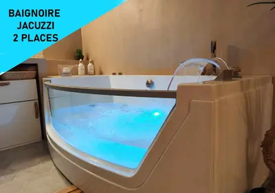 a bathroom with a tub with blue water in it at Terrasse & Spa dans Aix Hypercentre in Aix-en-Provence
