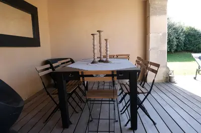 a dining room table and chairs on a deck at Provençal farmhouse, Mont Ventoux view, 2 pools (1 heated), Bédoin - 10 people in Bédoin