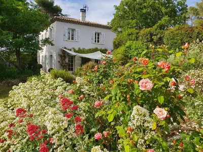 a garden of flowers in front of a white house at Lou Pantai, Bed and breakfast, small double Bedroom in Aix-en-Provence