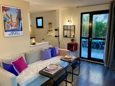 a living room with a white couch with colorful pillows at Ma place au sud Aix Terrasse Parking in Aix-en-Provence