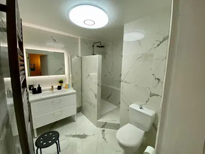 a white bathroom with a toilet and a sink at Ma place au sud Aix Terrasse Parking in Aix-en-Provence