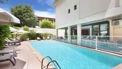 a swimming pool in front of a building at Ma place au sud Aix Terrasse Parking in Aix-en-Provence