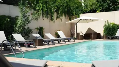 a swimming pool with lounge chairs and an umbrella at Ma place au sud Aix Terrasse Parking in Aix-en-Provence