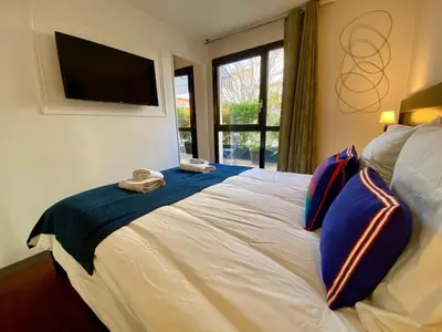 a bedroom with a bed with blue pillows and a television at Ma place au sud Aix Terrasse Parking in Aix-en-Provence