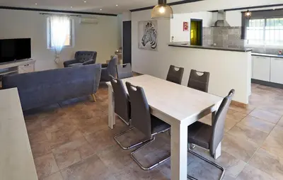 a dining room and kitchen with a table and chairs at Zèbre in Eyragues