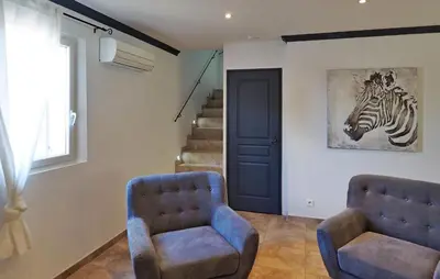 a room with two chairs and a zebra picture on the wall at Zèbre in Eyragues