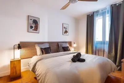 a bedroom with a large bed with a wooden headboard at CŒUR DU VENTOUX Carpentras Bel appart 6 places in Carpentras