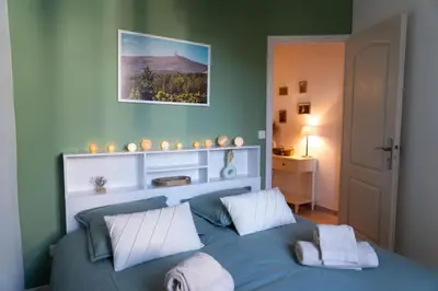a bedroom with a blue bed with two pillows at L'évasion de Bedoin, appartement in Bédoin