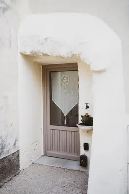 a front door of a white building with a potted plant at L'évasion de Bedoin, appartement in Bédoin