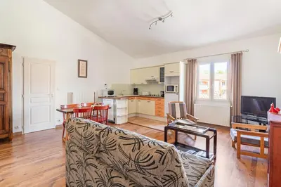 a living room with a couch and a kitchen at Charmant T2 2/4 Personnes in Pernes-les-Fontaines