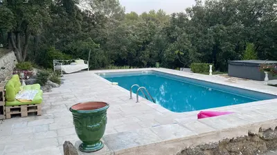 a swimming pool with a green planter next to it at LA BASTIDETTE PROVENçALE in Jouques