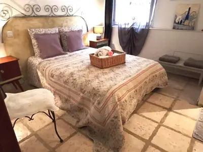 a bedroom with a bed with a teddy bear in a basket at Appartement en campagne au coeur du luberon in Roussillon