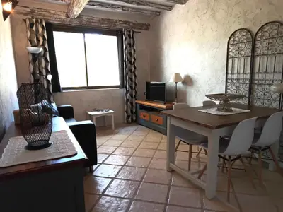 a living room with a table and a television at Appartement en campagne au coeur du luberon in Roussillon