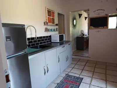 a kitchen with a refrigerator and a sink at Appartement en campagne au coeur du luberon in Roussillon