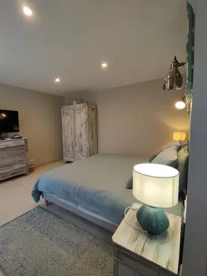a bedroom with a bed and a table with a lamp at Le mas de Roussillon in Roussillon