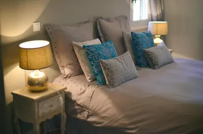 a bed with blue and gray pillows on it at Le mas de Roussillon in Roussillon