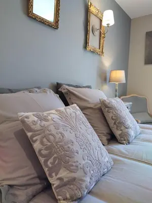 a bedroom with two beds with pillows and two mirrors at Le mas de Roussillon in Roussillon