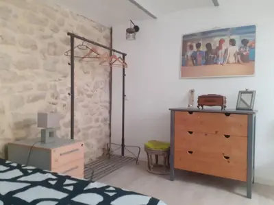 a bedroom with a bed and a dresser and a wall at Maison restaurée à l'ancienne avec terrasse in Jouques