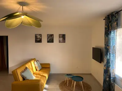 a living room with a couch and a ceiling fan at Appartement cosy in Aix-en-Provence